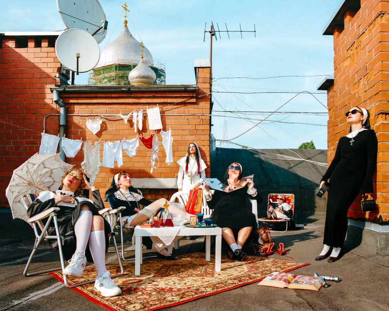 Sunday Service — A congregation of sun-worshippers on a Riga rooftop, staged as a modern-day ritual of rest.